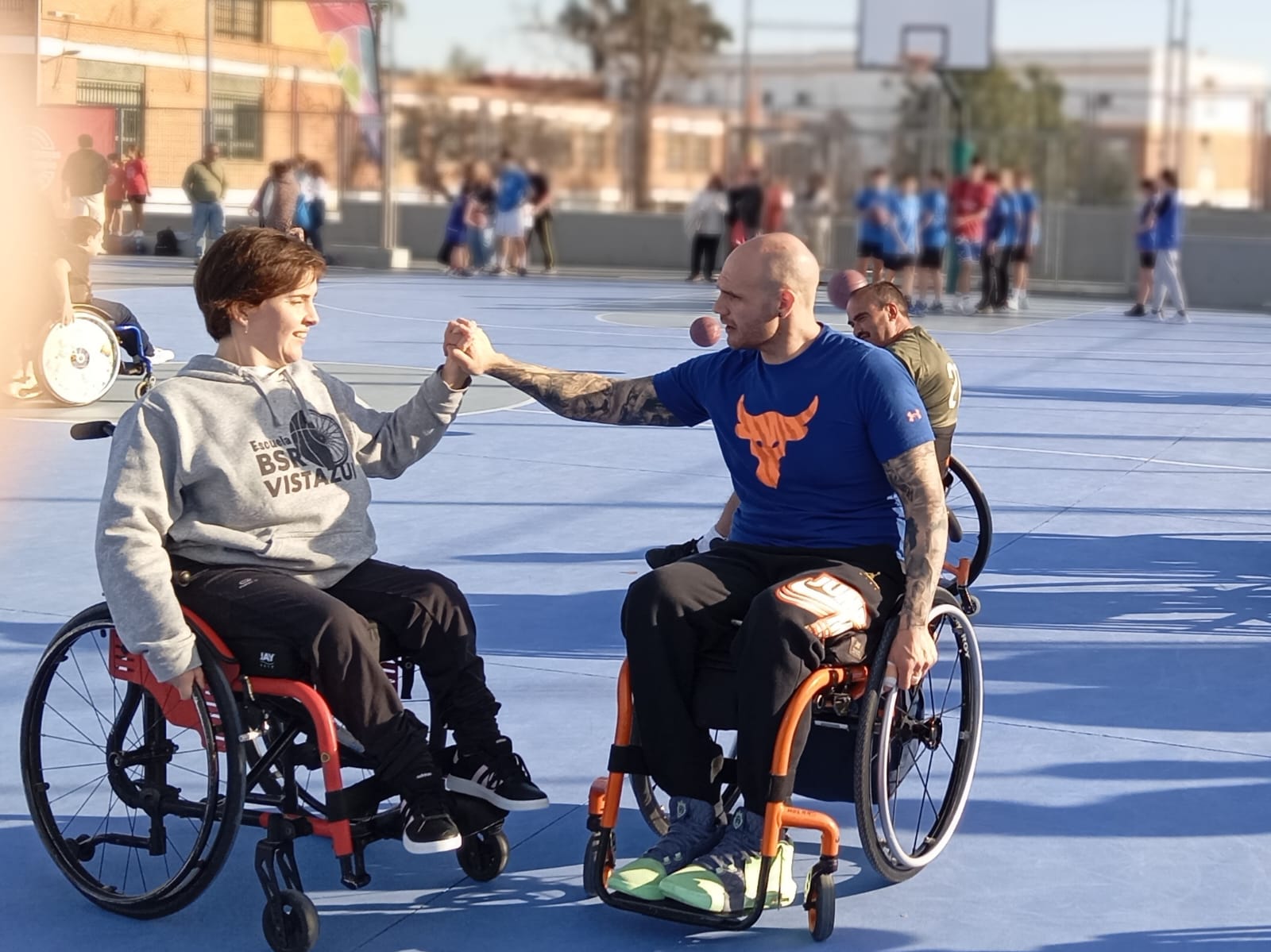 Fotografía de un jugador de bsr apoyando a un alumno de la escuela dandole la mano